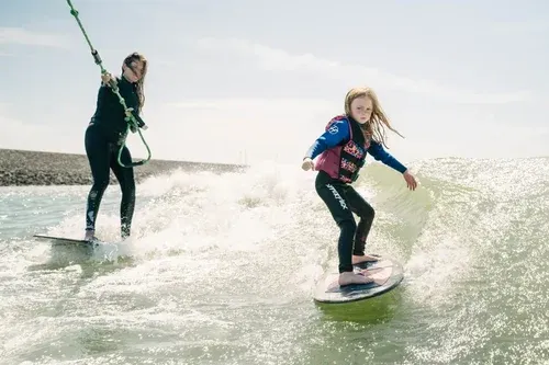 A lady and a girl wakesurfing 