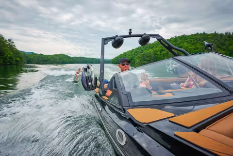 boat in water pulling a wakesurfer